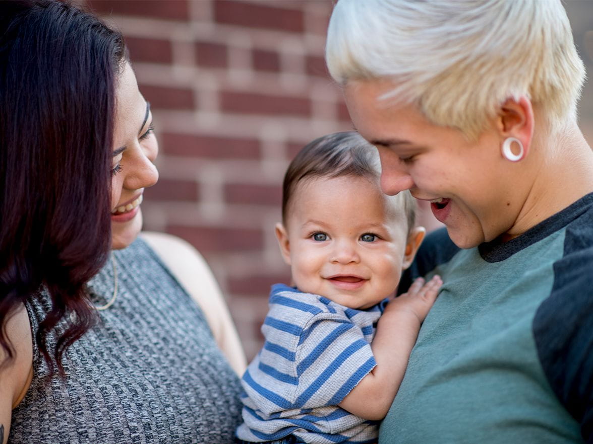 smiling women holding smiling baby