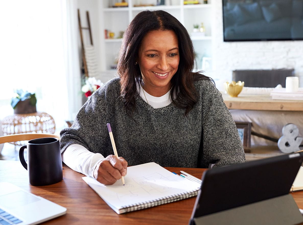 women taking notes on laptops