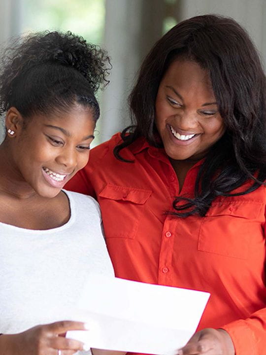 Daughter showing mother college acceptance letter