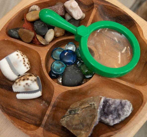 Daycare sensory objects of rocks shells and a magnifying glass