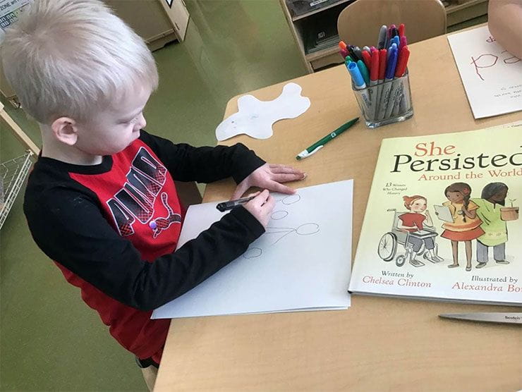 A child drawing on paper.