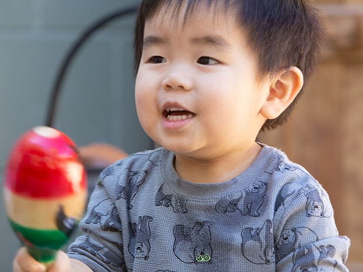 Toddler playing with maraca and singing at Bright Horizons day care 