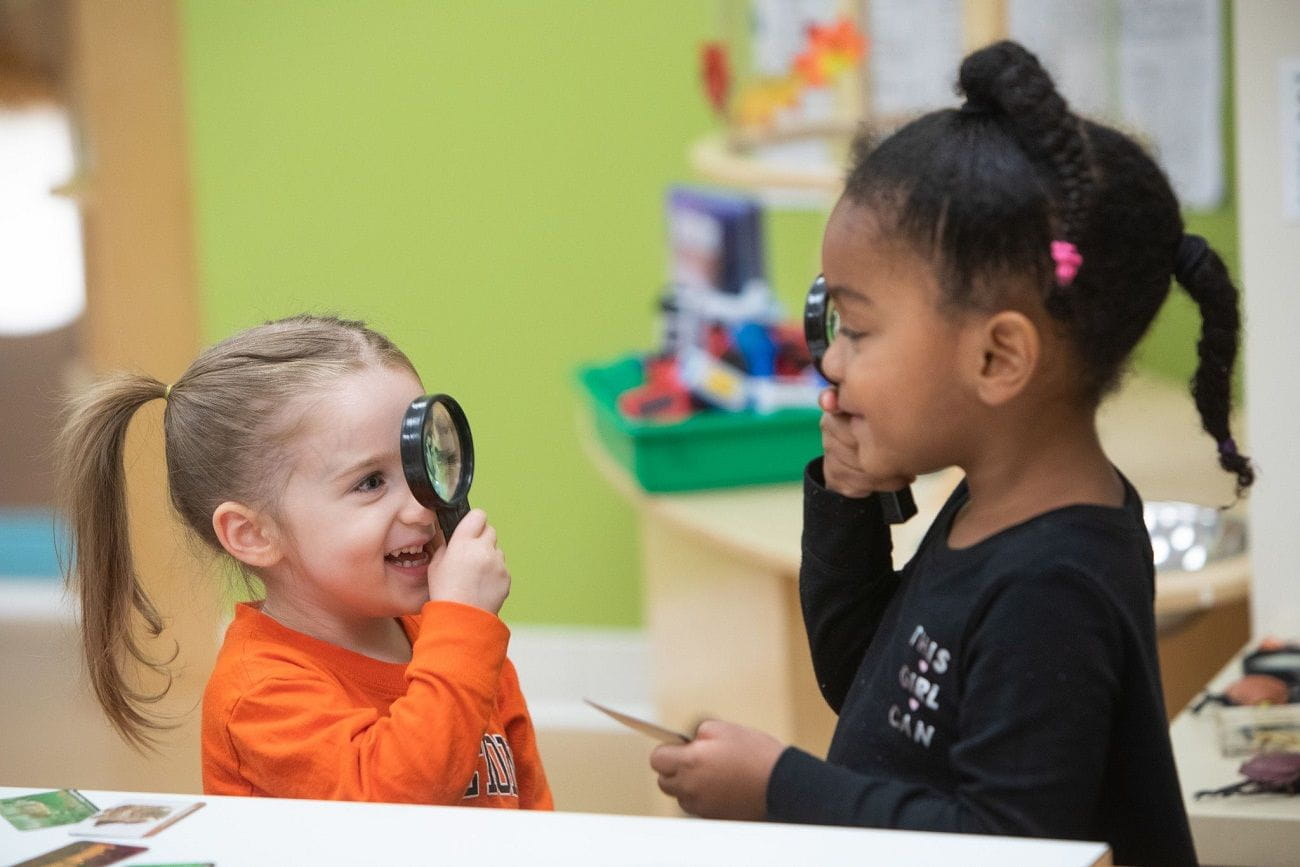 Two children playing with magnifying glasses