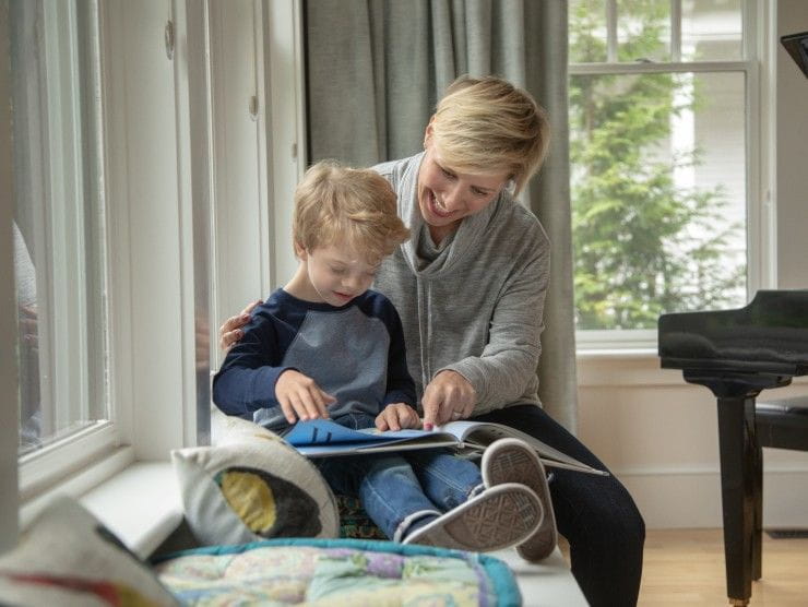 mom reading a book to child 