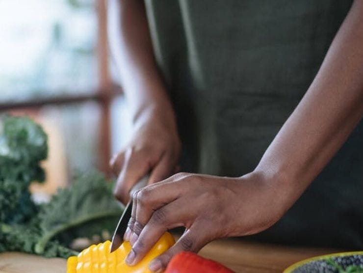 Adult cutting up veggies for snack time at home