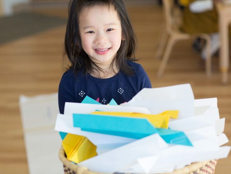 child holding basket of paper 