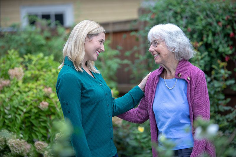 Women and her elderly mom standing in the garden