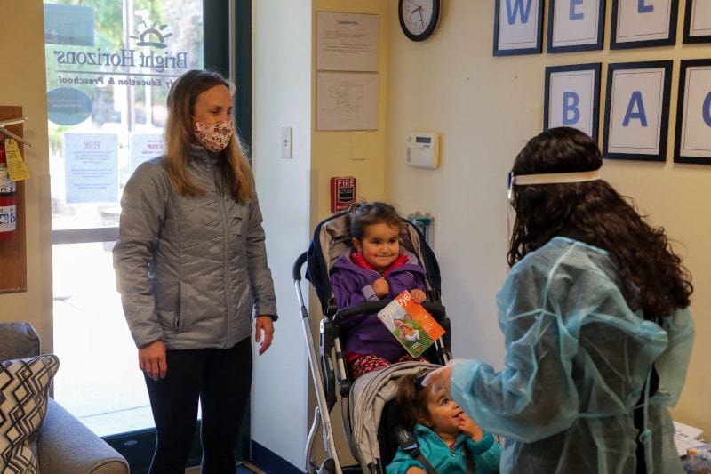 Working mom dropping kids off at back-up care center