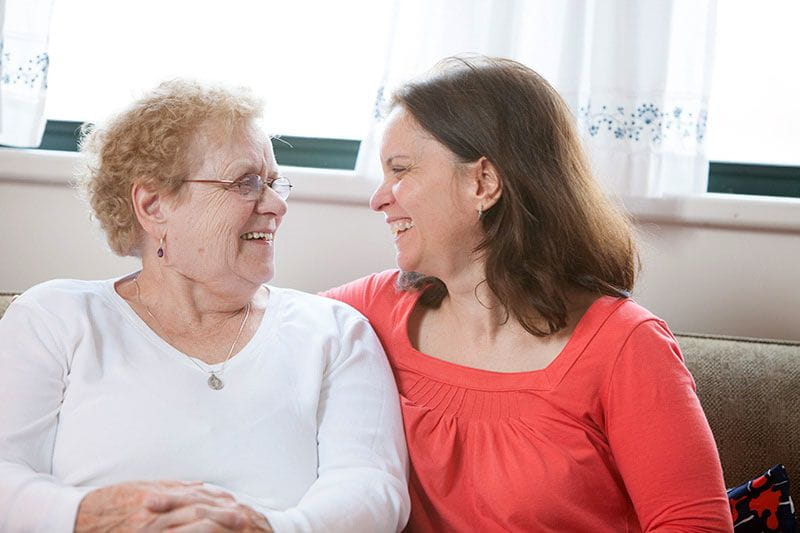 Working woman sitting with her elderly mom