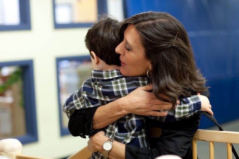 Working mom dropping her son off at on-site child care center